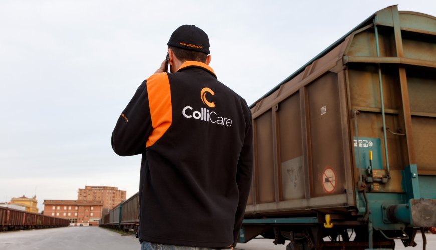 The back of a ColliCare employee in branded clothes at the rail station, talking on the phone