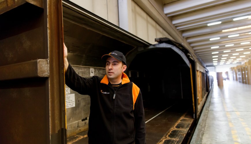 ColliCare employee in branded clothes at the rail station standing in a vagon